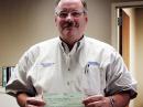 Okmulgee County Emergency Management Director Timothy D. Craighton holds a grant award check from Operation Round Up and the ECE Foundation.